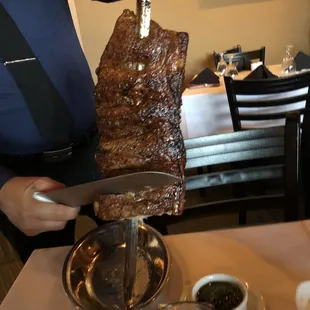 a man holding a knife and cutting the meat