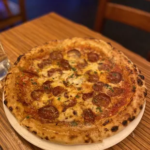 The VIP Wood-fired Pizza $25.00 tomato, salametto piccante, 26-month aged gouda, manchego semicurado, grana padano, black truffle honey