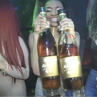 a woman holding two bottles of beer