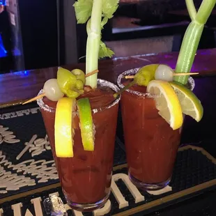 two bloody cocktails with garnish and lime garnish