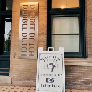 a sign in front of a brick building