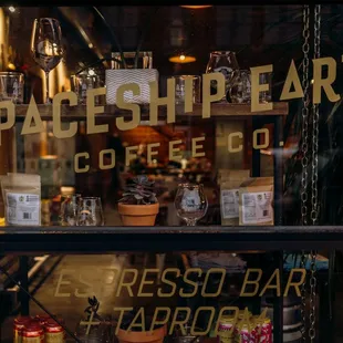 a storefront window with a variety of coffees
