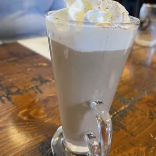 a glass of milkshake with whipped cream on top