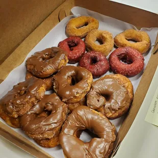 Chocolate glazed donuts (left), glazed donuts (under the chocolate), red velvet cake donut (middle), cinnamon cake donuts (right)