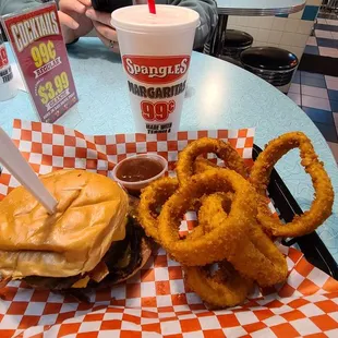 a burger and onion rings on a table