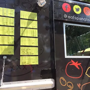 a black food truck with yellow stickers on it