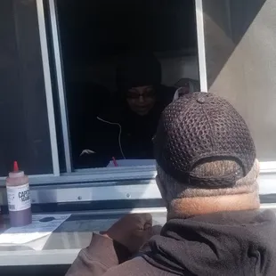 a man looking out the window of a food truck
