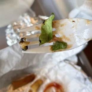 a fork holding a piece of pizza