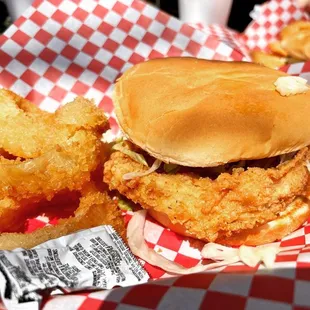 a fried chicken sandwich and onion rings