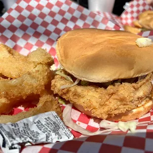 a fried chicken sandwich and onion rings