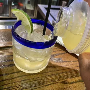 a margarita being poured into a glass