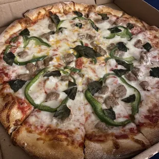 Medium pizza with sausage, bell pepper, and basil