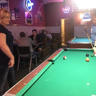 a man and a woman playing pool