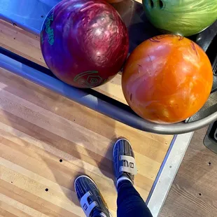 a person standing in front of a bowl of bowling balls