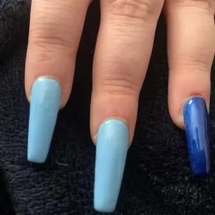 On the nail with the dark shade of blue you can see the cut from the glue pushing out from under the nail and into her skin.