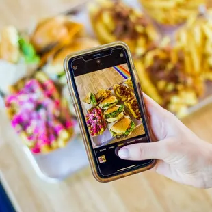 a person taking a picture of a plate of food