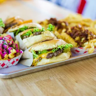 a tray of hamburgers, fries, and coleslaw