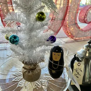 Nun Russian doll next to a Christmas tree
