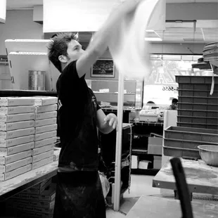 a black and white photo of a man in a kitchen