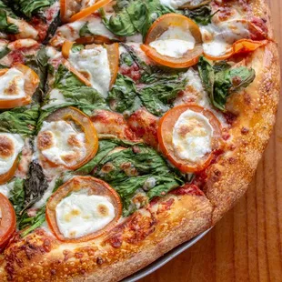 a pizza with tomatoes and spinach