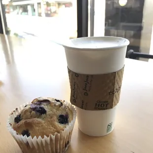 Latte and blueberry muffin on a sunny day.