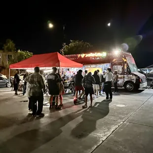 a group of people standing in a parking lot
