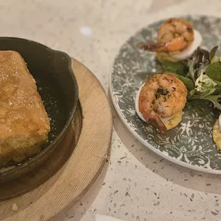 Cornbread- how it looks in 2023- a square block, dry af, not even served with any butter. Also pictured: Creole deviled eggs- decent.
