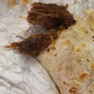a burrito with meat on it
