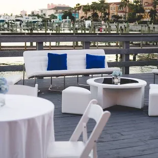 Outdoor cocktail hour on a deck overlooking the water with our rental lounge furniture