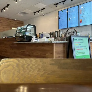 a restaurant counter with a menu in the background