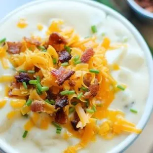 a bowl of potato soup with bacon and cheese