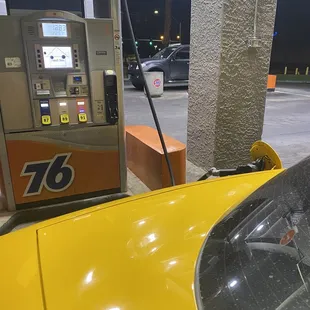 a yellow car at a gas station