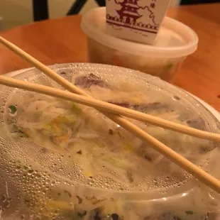 a bowl of soup and chopsticks