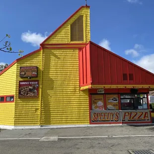 a yellow building with a red roof