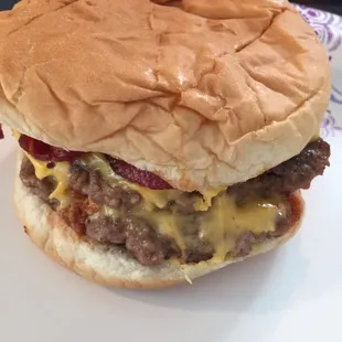 Double cheeseburger with onions bacon and chili.