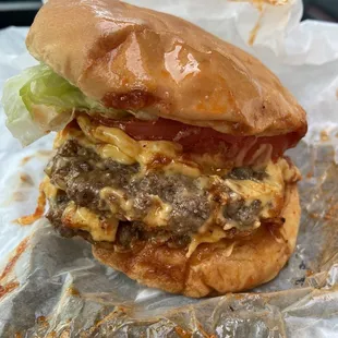 a cheeseburger with lettuce and tomato