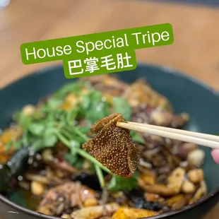 a person holding chopsticks over a bowl of food