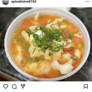 a bowl of soup with shrimp and vegetables