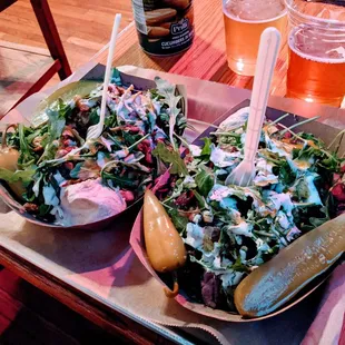 two plates of salad and a beer