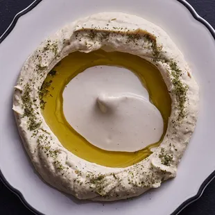 a bowl of hummusle and olive oil