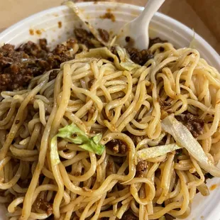 a plate of noodles and meat