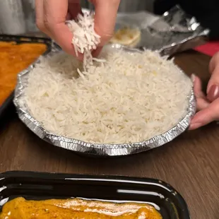 a person putting cheese on top of rice