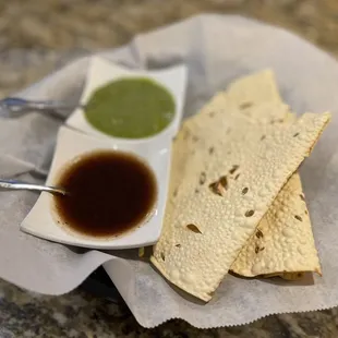 Complimentary, crispy bread with red sauce (sweet) and green sauce (spicy).