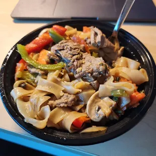 a bowl of noodles with meat and vegetables