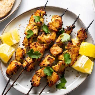 a plate of chicken skewers