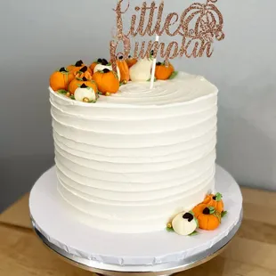 a white cake with a little pumpkin topper
