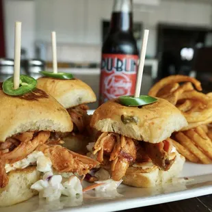 a plate of pulled pork sandwiches and french fries