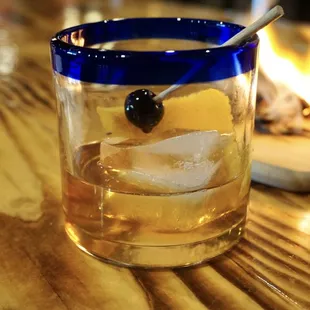 a glass of whiskey with a spoon in it