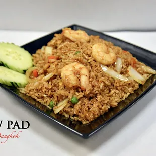 a plate of fried rice with shrimp and vegetables