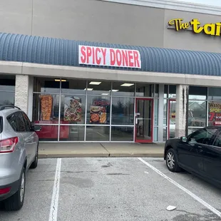 two cars parked in front of a store